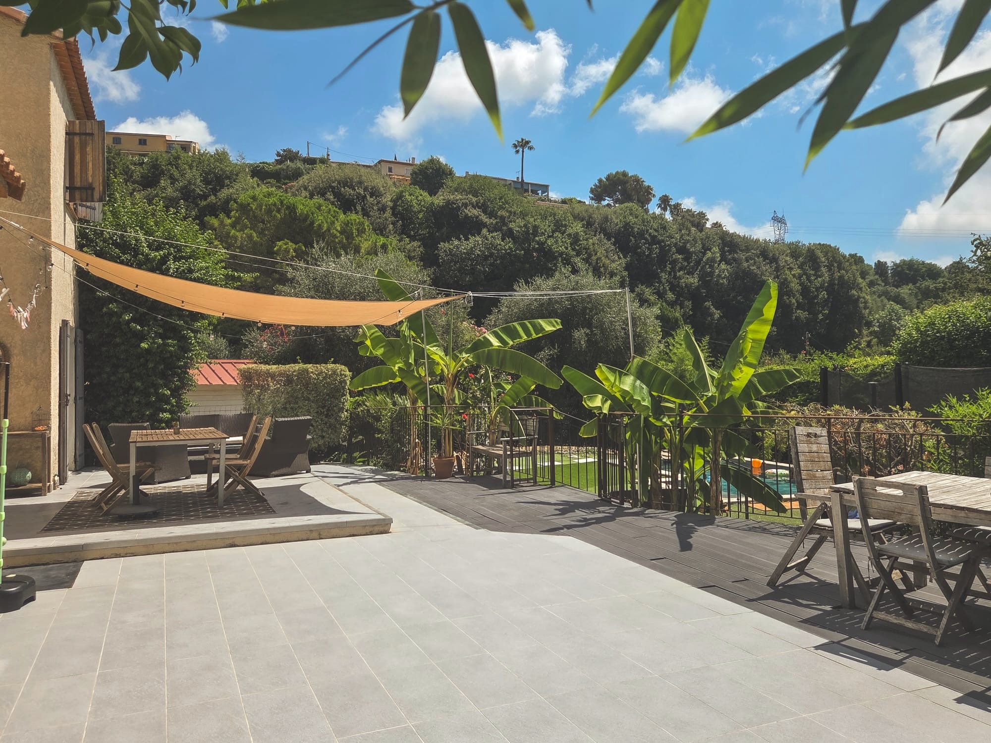 Grande terrasse avec voile d'ombrage et vue sur le jardin